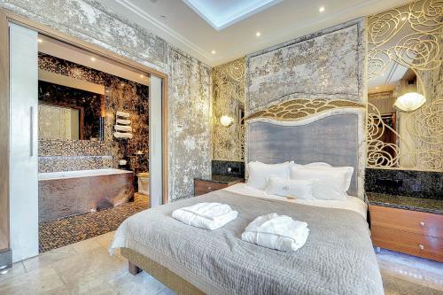索波特Mała Anglia Deluxe Rooms & SPA的一间卧室设有一张大床和一个浴缸