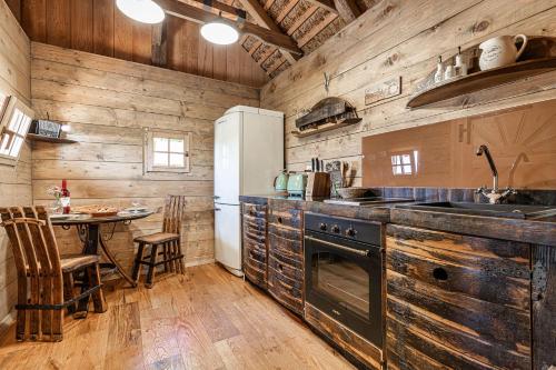 奥托亚克Vineyard Cottages Skatlar - Happy Rentals的厨房设有木墙、桌子和冰箱。