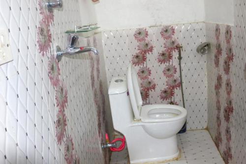 DeorāliYours Family Restaurant and Homestay的浴室位于隔间内,设有白色卫生间。