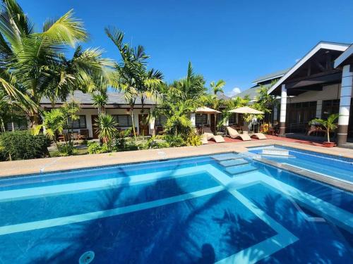 巴旺Marand Beach Resort的房屋前的游泳池