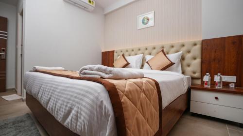 班加罗尔La Serene Business Hotel的一间卧室配有一张大床和毛巾