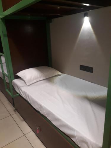 埃尔讷古勒姆CosyCove的一张绿色双层床,上面有白色枕头