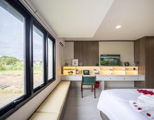 登巴萨Verdant Bali Sekar Sari的卧室配有一张床、一张书桌和窗户。