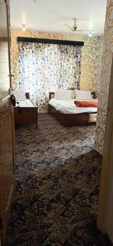斯利那加Hotel Kashmir Heaven的一间卧室设有两张床和窗户。