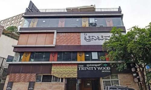 班加罗尔The Trinitywood Hotel & Restaurant的一座高大的建筑,上面有标志