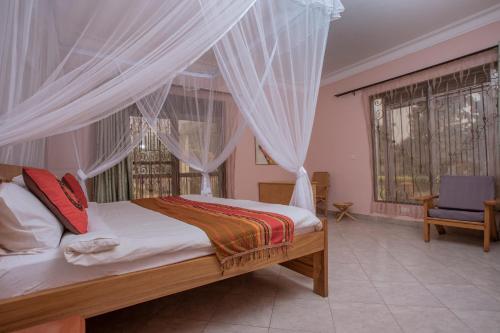 波特尔堡SILVER OAKS HOTEL Boma的一间卧室配有带窗帘的床和椅子