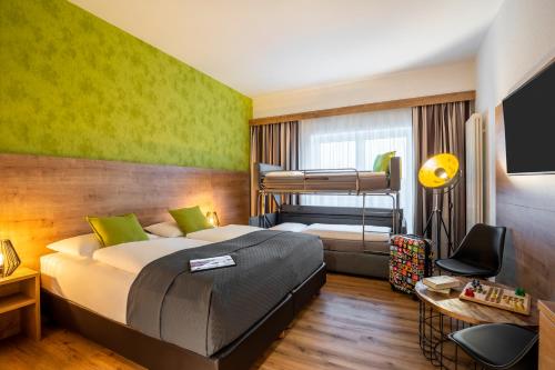 巴特恩豪森巴特恩豪森市美居酒店的一间卧室配有一张床和两张双层床。