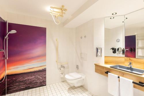 巴特恩豪森巴特恩豪森市美居酒店的一间带盥洗盆和墙上绘画的浴室