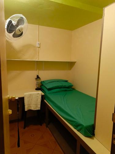 马朱罗Maburo sea breeze suites的小房间设有一张床和一个风扇