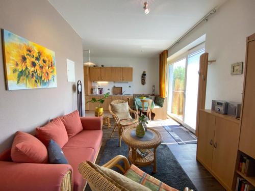 巴斯托夫Bastorfer Landhaus的一间带红色沙发的客厅和一间厨房