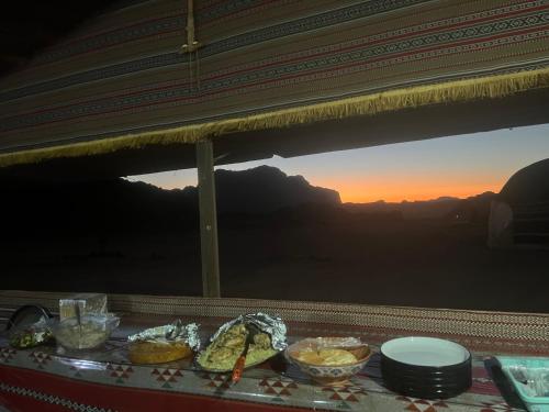 瓦迪拉姆Wadi rum Bedouin Experience的餐桌,配有碗,享有山景