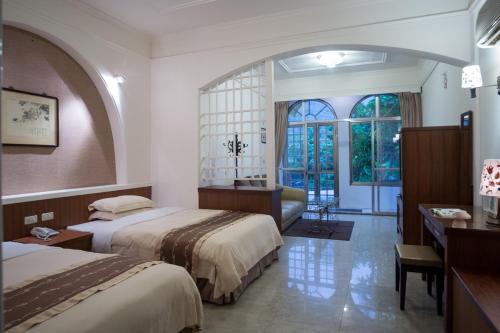 Wenquan知本泓泉温泉渡假村的酒店客房配有两张床和一张书桌