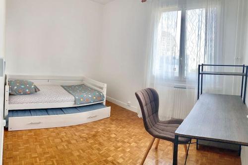 诺伊斯·勒·格兰德Appartement bien situé的一间卧室配有一张床、一把椅子和一张桌子