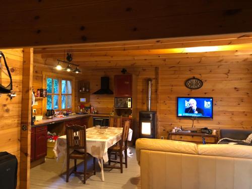 拉兰Maison Bois的厨房以及带桌子和电视的客厅。