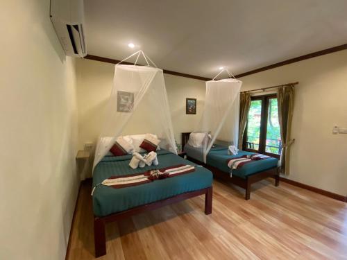 考索Khao Sok River & Jungle Bungalow的一间带两张床和一张沙发的客厅