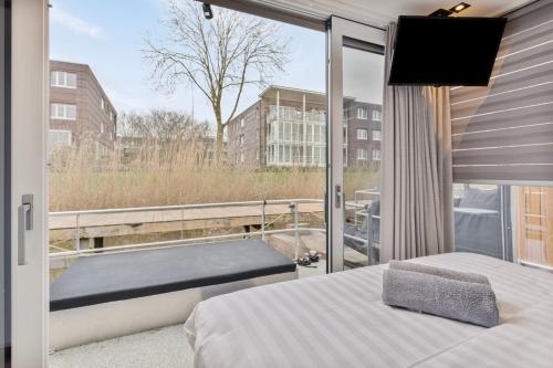 泽沃德Luxurious waterloft near beach and centre的一间卧室设有1张床和1扇窗户的阳台