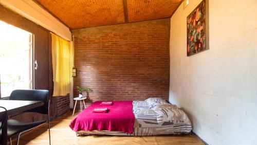 斯勒曼Rumah Gaharu - Kamar Ngarep 001的砖墙房间的一个床位