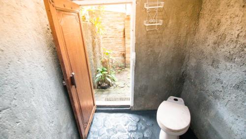 斯勒曼Rumah Gaharu - Kamar Ngarep 001的一间带卫生间和开放式门的浴室