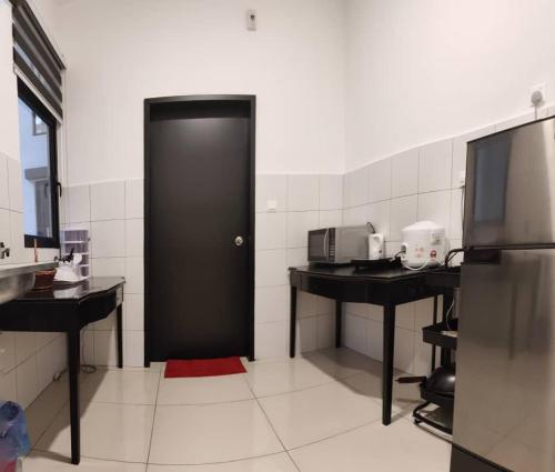 普特拉贾亚MFA Putrajaya Homestay的厨房里设有一扇黑色的门,配有两个柜台