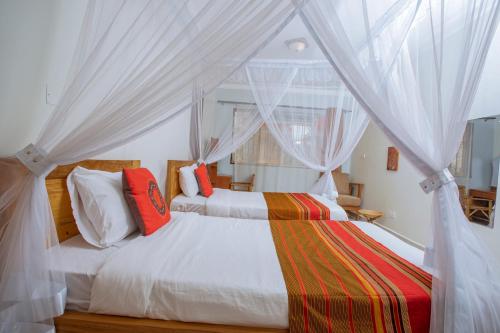 波特尔堡SILVER OAKS HOTEL Boma的卧室配有白色窗帘的床