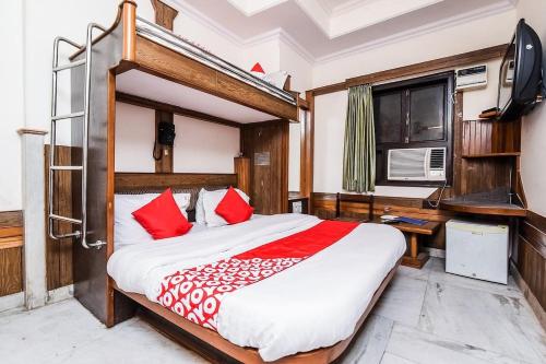 新德里Hotel Cottage Crown Plaza By My Rooms的一间卧室配有一张带红色枕头的大床