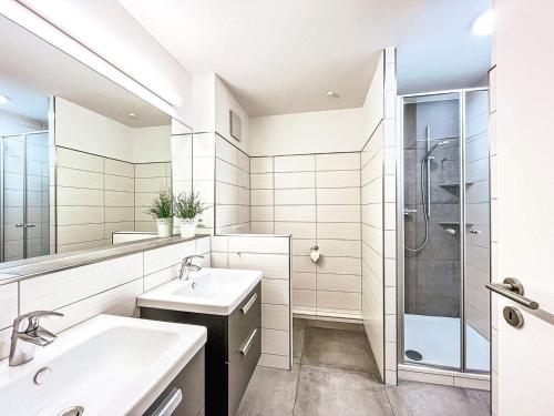 博尔滕哈根Ferienwohnung Papillon Boltenhagen的白色的浴室设有2个盥洗盆和淋浴。