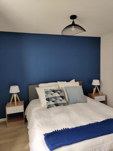 博韦Grande Maison Proche Aéroport的一间卧室设有蓝色的墙壁和一张床
