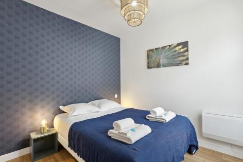 蒙特勒伊862 Suite Tulipe - Superb apartment的一间卧室配有蓝色的床和毛巾