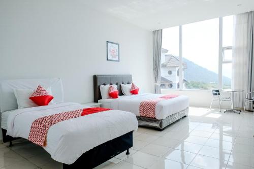 特勒贡OYO 1194 Villa Bukit Panderman Residence的一间卧室设有两张床和大窗户