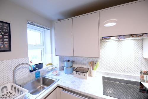 伦敦2 BEDROOM FLAT in WOOD GREEN PICCADILLY LINE的厨房配有白色橱柜和水槽