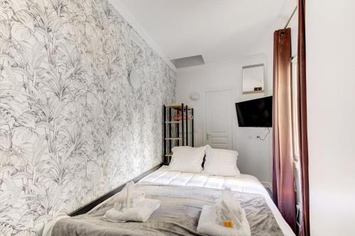 巴黎326 Suite Biot - Superb apartment in Paris的一间小卧室,配有床和壁画