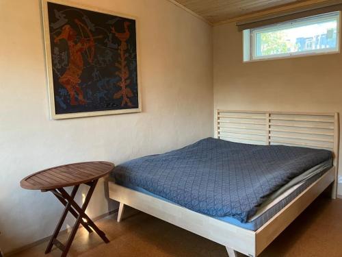 坦佩雷Garden house near centre的一间卧室配有一张床、一张桌子和一个窗户。