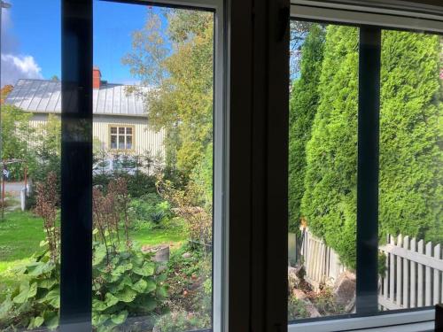 坦佩雷Garden house near centre的享有花园和房屋景致的窗户。