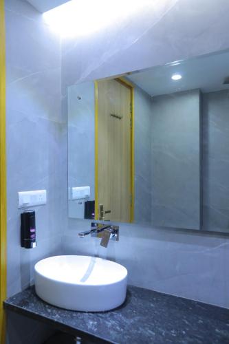 新德里Hotel The Glitz的浴室设有白色水槽和镜子