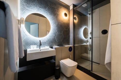 敖德萨Ultramarinn Hotel的一间带水槽、卫生间和镜子的浴室