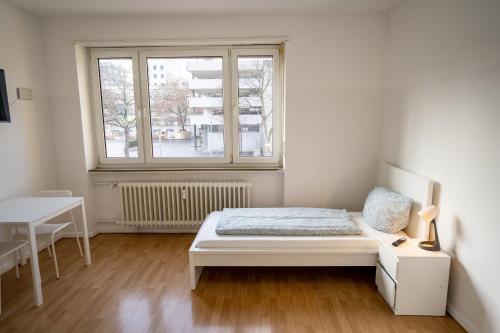 莱茵河畔路德维希港ATRIUM - großzügige Wohnung LUDWIG79的白色的卧室设有床和窗户