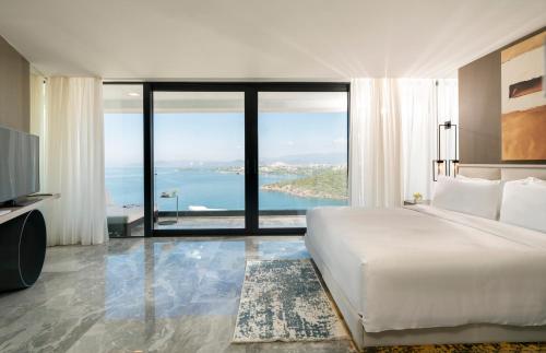 博阿齐奇Le Méridien Bodrum Beach Resort的一间卧室配有一张床,享有海景