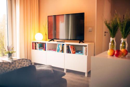博尔库姆Haus Jelena Appartement 5的一间客厅,客厅内配有一台电视,位于白色娱乐中心