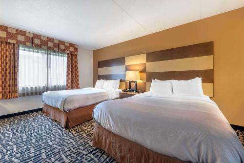 罗切斯特梅奥诊所区优质套房酒店的酒店客房设有两张床和大窗户。