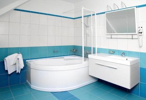 捷克特热博瓦Pivovar a restaurace Faltus的蓝色和白色的浴室设有浴缸和水槽