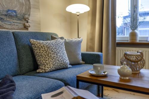 博尔库姆Commandeur-Huus Wohnung 2的客厅配有蓝色的沙发和茶几