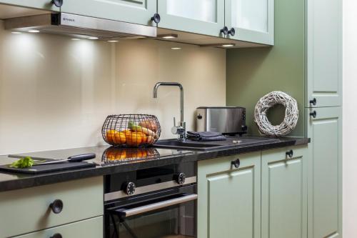 博尔库姆Commandeur-Huus Wohnung 2的厨房配有水槽,柜台上备有一篮水果
