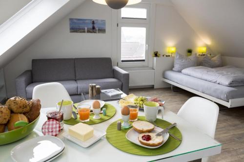 博尔库姆Haus Nordstern Wohnung 5的客厅配有餐桌,提供早餐食品