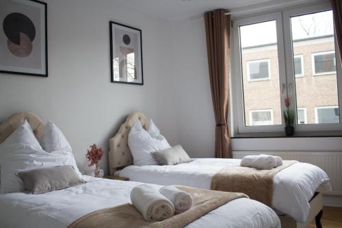 不莱梅Timeless Apartment Bremen-Neustadt的一间卧室配有两张带毛巾的床