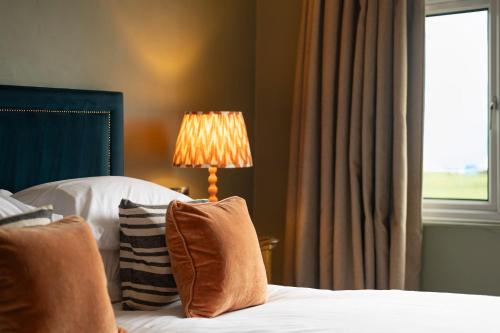 利特尔东海滩宾馆的一间卧室配有一张带灯和窗户的床