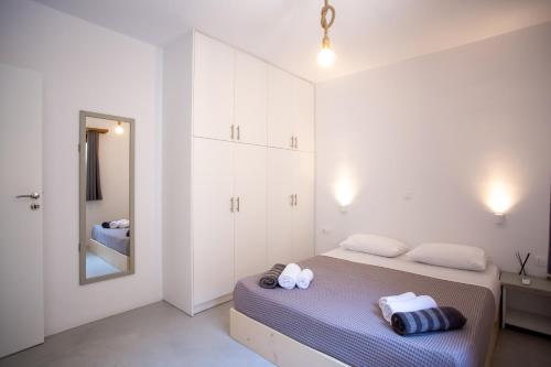 米克诺斯城Aqua Breeze Seaview Pool Suites Mykonos的白色卧室配有床和镜子