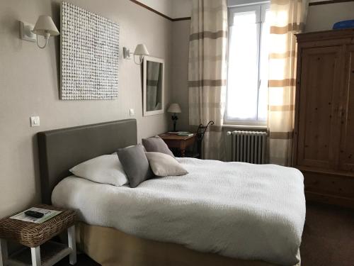 滨海贝尔克Logis Hôtel & Restaurant "Au Gré du Vent"的一间卧室配有一张带白色床单的床和一扇窗户。