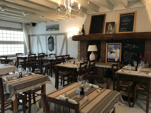 滨海贝尔克Logis Hôtel & Restaurant "Au Gré du Vent"的一间带木桌和椅子以及黑板的餐厅