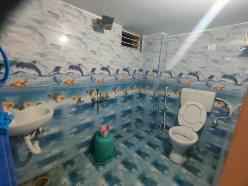 蒂鲁瓦纳马莱Pushpa Mahal A/C & Pushpa Residency的浴室设有卫生间和水槽,墙上有鱼