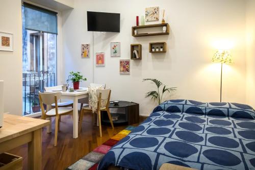 卡塔尼亚Gli Appartamenti al Duomo的一间卧室配有一张床铺和一张桌子,还有一间用餐室